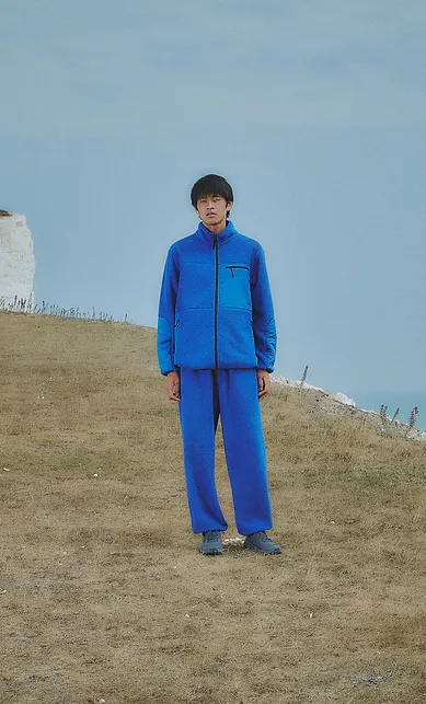 Man wearing a blue jacket and trousers, standing on chalk cliffs