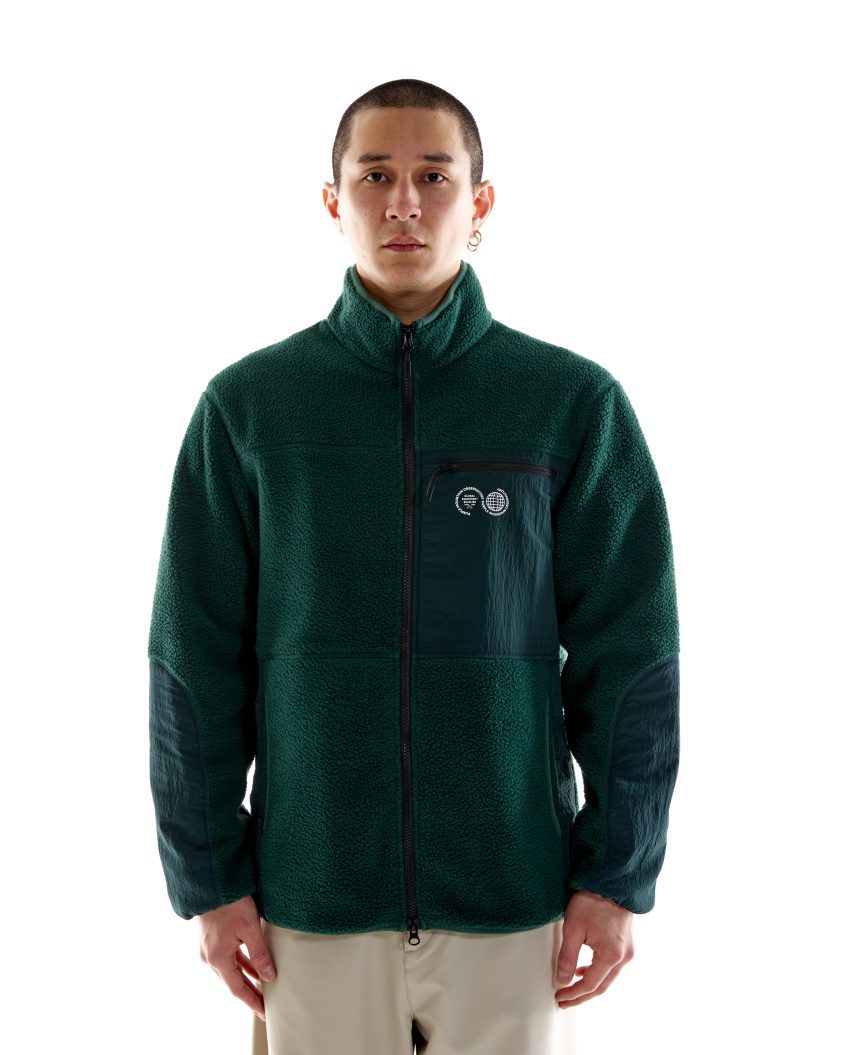 Model wearing Borg Sherpa Fleece – Pine Green with high collar and nylon panels. Borg Sherpa Fleece made from recycled fabric with durable construction