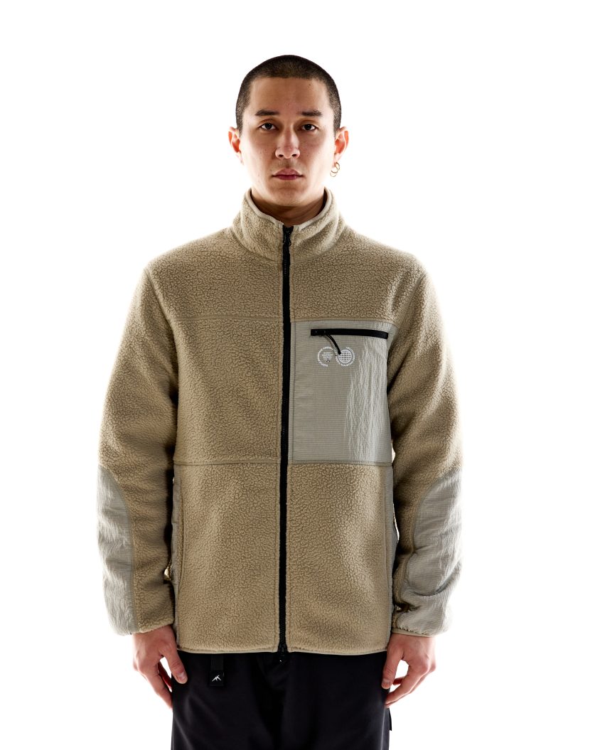 Model wearing Borg Sherpa Fleece – Stone with high collar and nylon panels. Borg Sherpa Fleece made from recycled fabric with durable construction