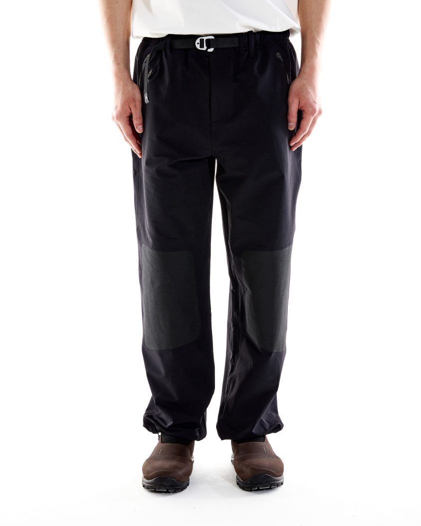 Model wearing Forest Pant – Black with reinforced knee print. Forest Pant designed for mobility and resilience in outdoor use.