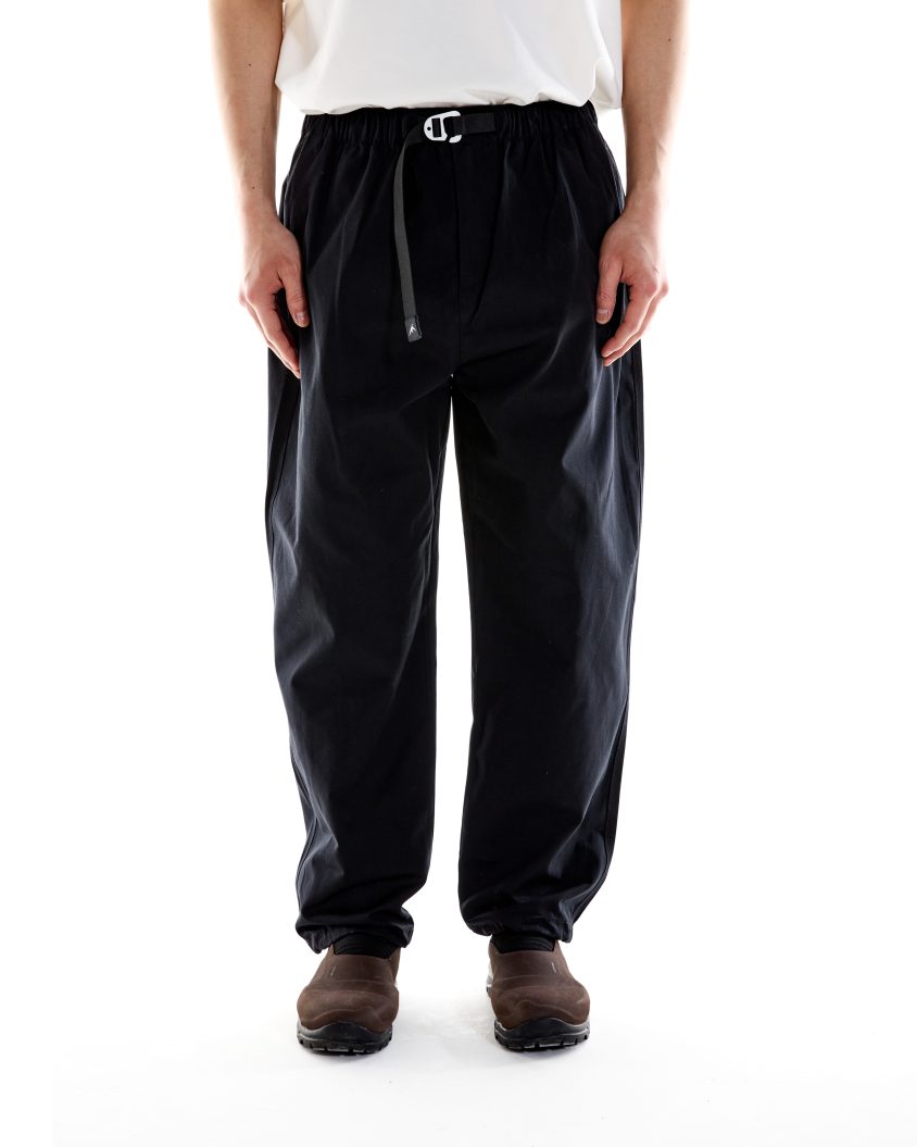 Model wearing Alpine Cotton Pant – Black with grosgrain belt and branded tab Breathable cotton-poly trousers designed for hiking, exploring, and everyday wear