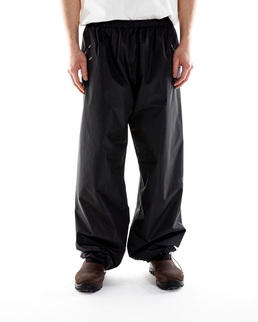Model wearing Deluge Pant – Black with waterproof over-trouser design Deluge Pant – Black designed for protection in harsh, wet conditions