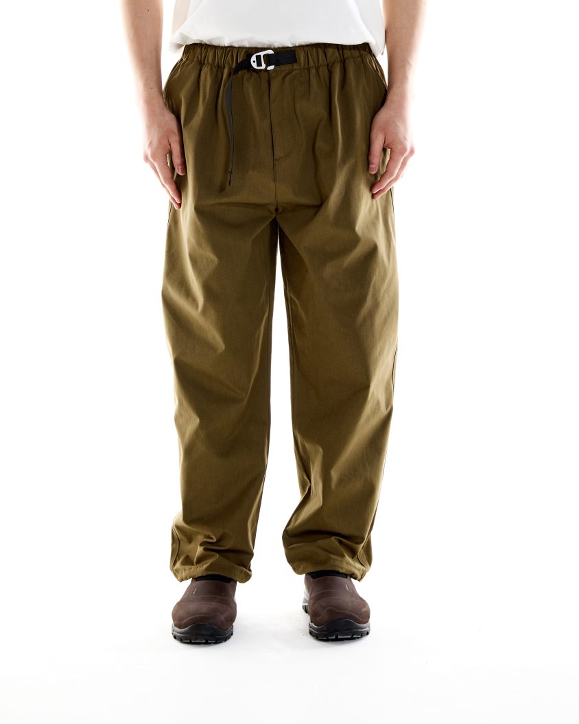 Model wearing Alpine Cotton Pant – Khaki with grosgrain belt and branded tab Breathable cotton-poly trousers designed for hiking, exploring, and everyday wear