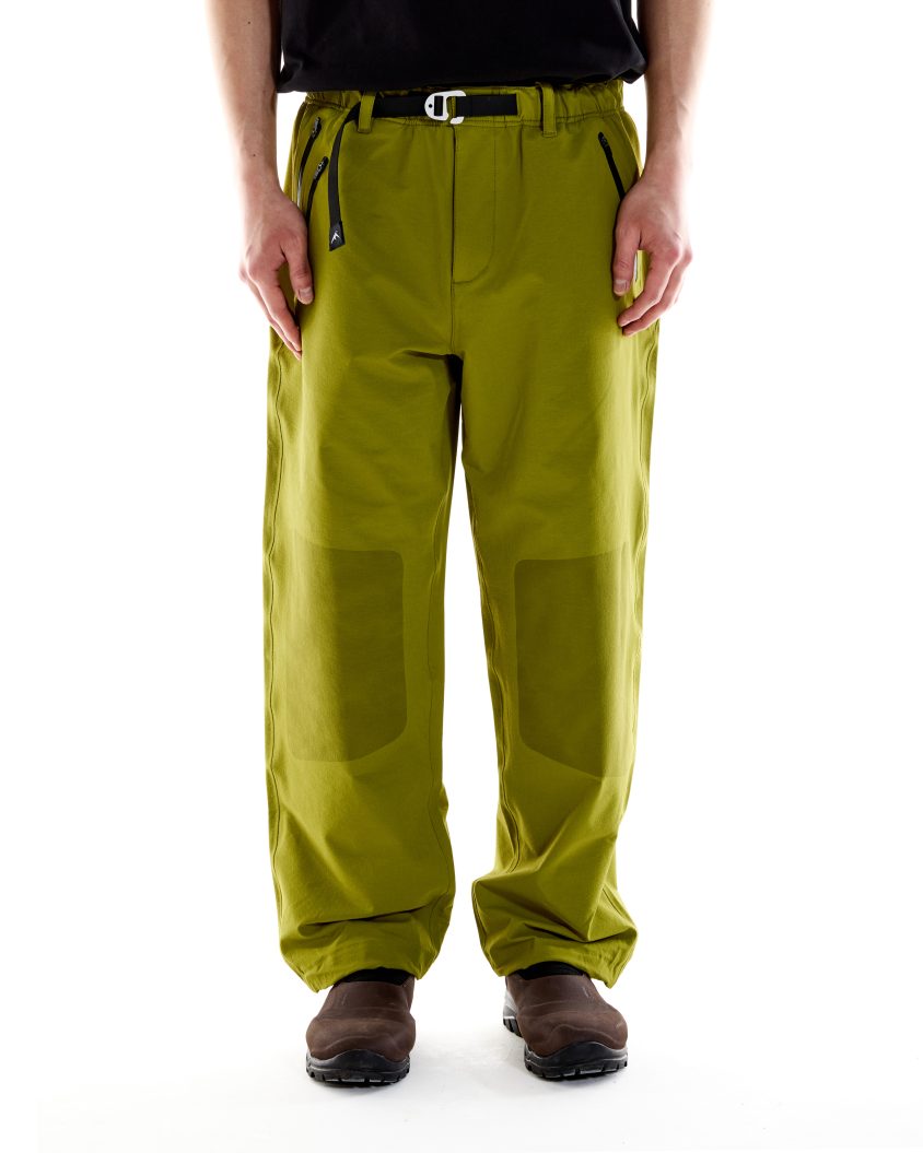 Model wearing Forest Pant – Olive with reinforced knee print. Forest Pant designed for mobility and resilience in outdoor use.