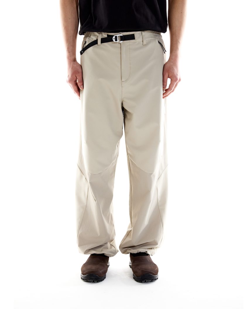 Model wearing Terrain Pant – Stone with articulated fit and darted knees, designed for all-weather outdoor use