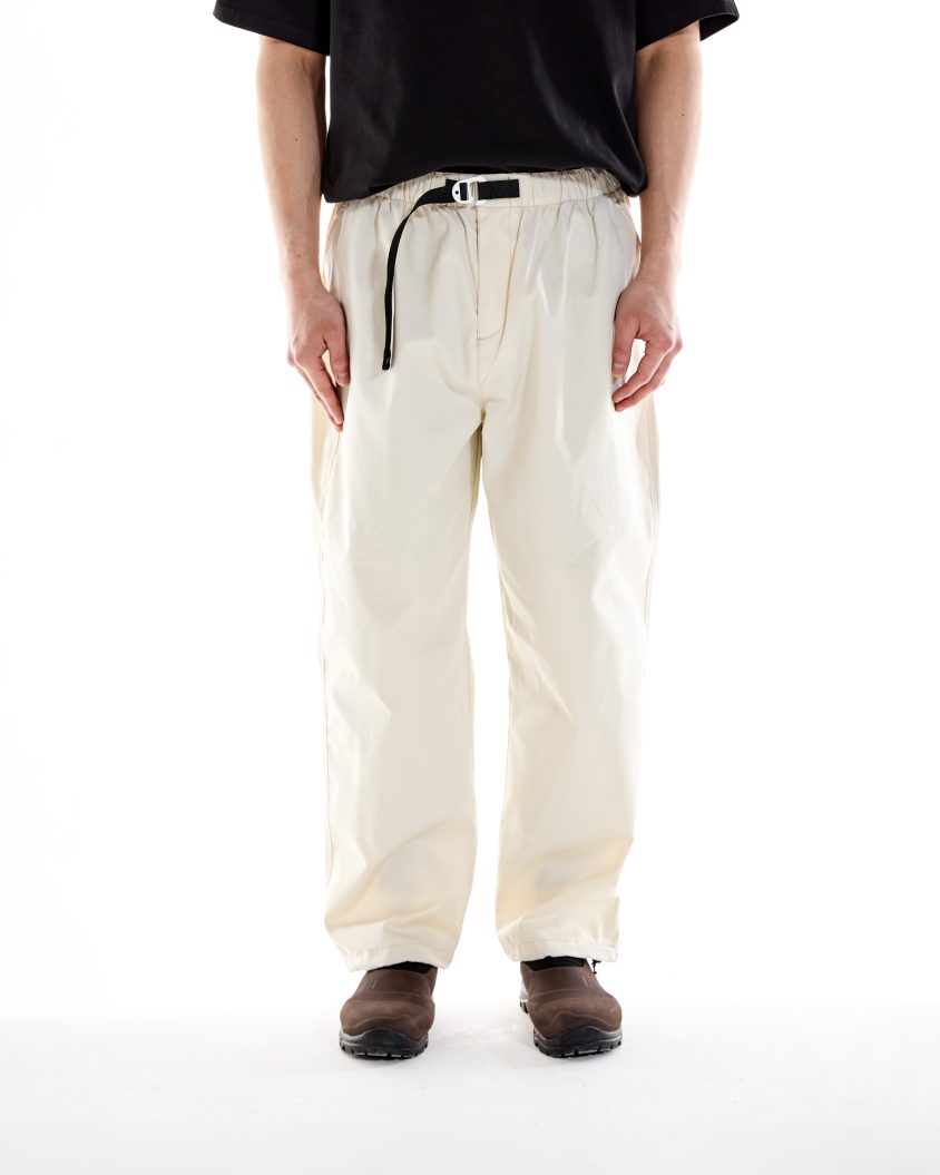 Model wearing Alpine Cotton Pant – Cream with grosgrain belt and branded tab Breathable cotton-poly trousers designed for hiking, exploring, and everyday wear
