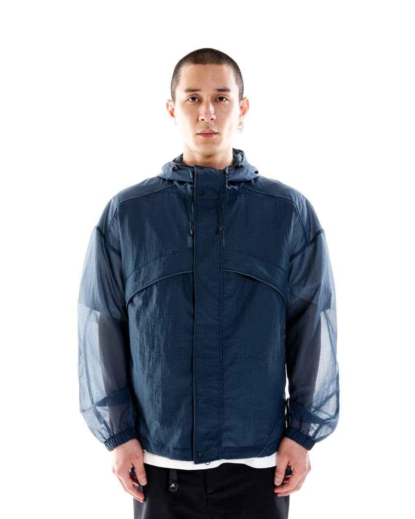 Model wearing Field Jacket – Ink with semi-transparent Ripstop Mesh shell Lightweight mesh jacket with modern silhouette and technical features