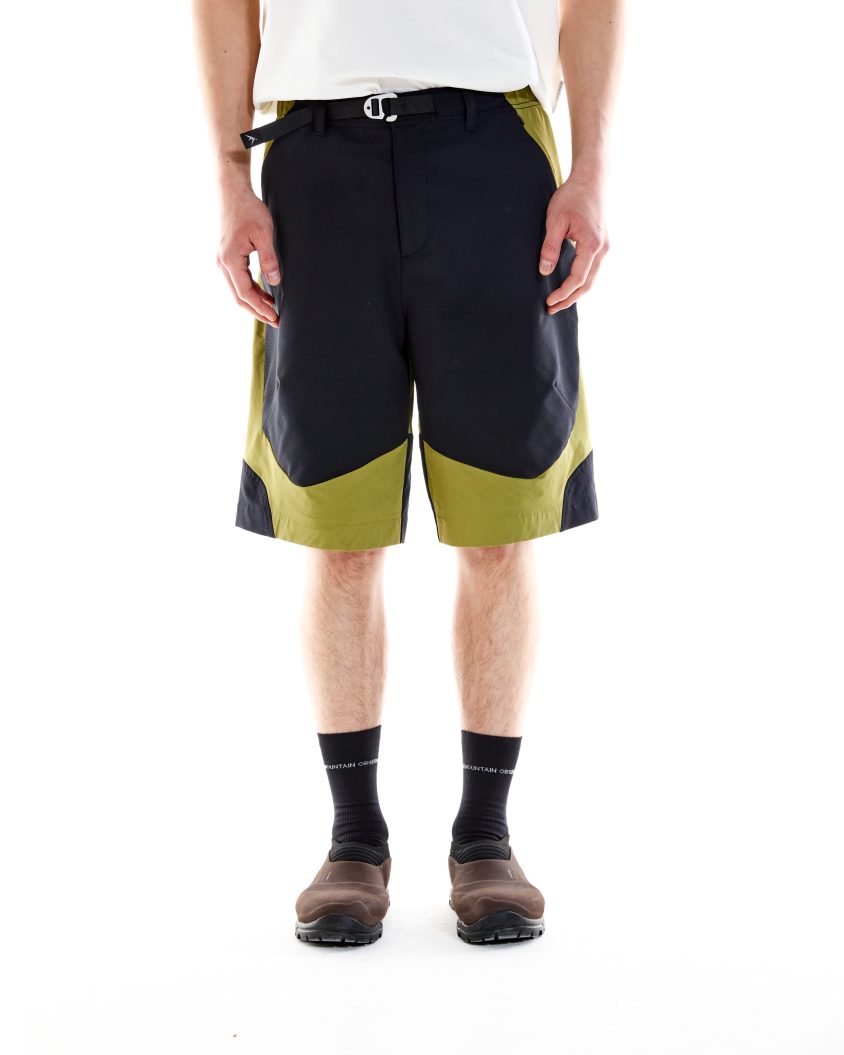 Model wearing Terrain Shorts Olive with stretch ripstop panels at front and seat. Outdoor-ready shorts designed for movement with breathable, durable construction