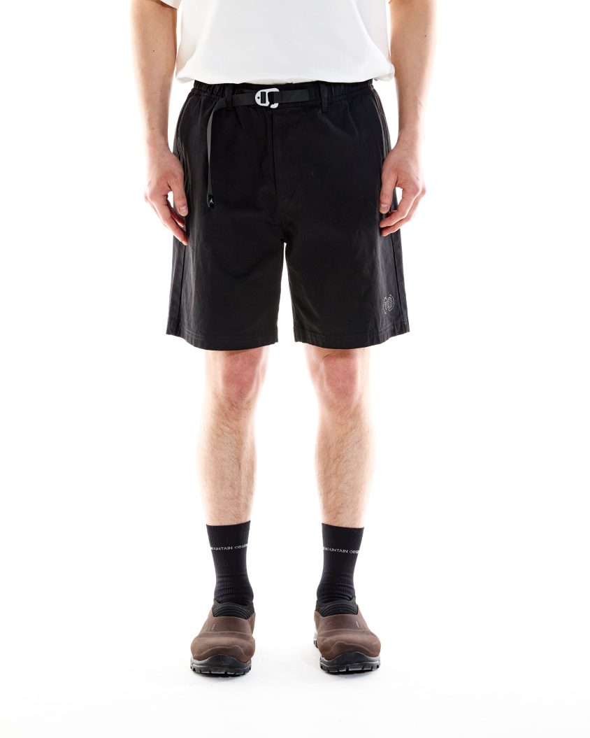 Model wearing Trek Short Black with built-in belt and cotton construction. Outdoor shorts designed for comfort, movement, and trail readiness.